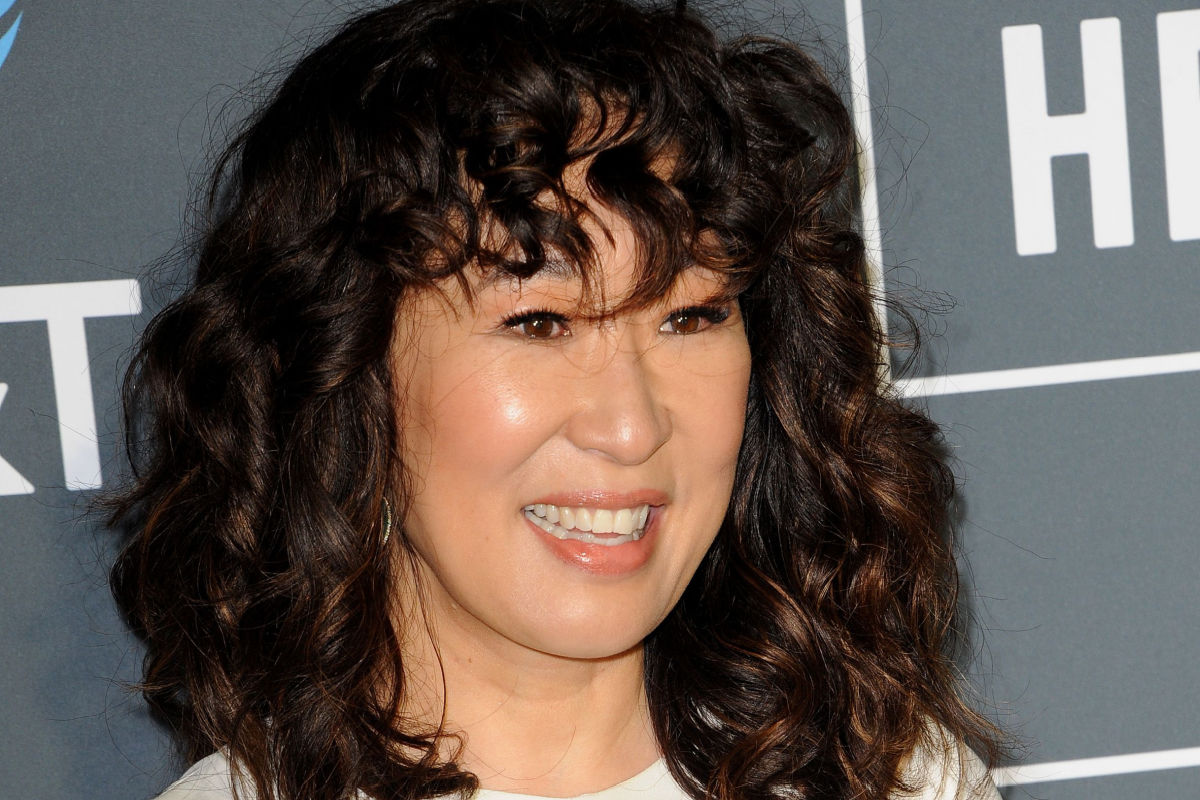 Atriz Sandra Oh com cabelo cacheado e de franja 